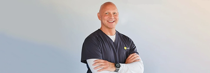 Shockwave Technician Kurt O'Neill Smiling In Black Scrubs